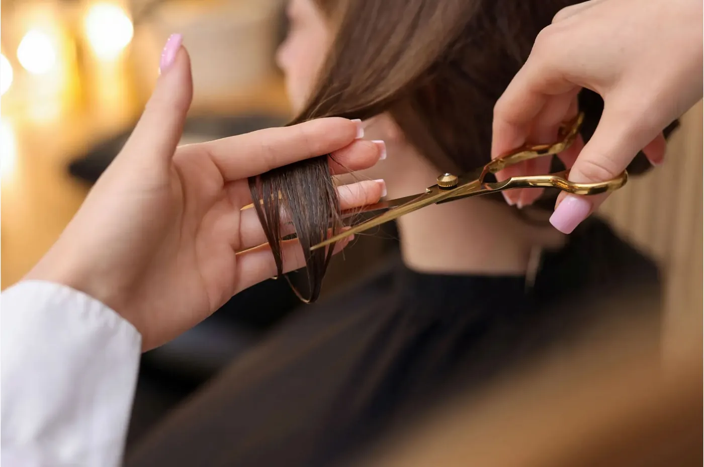 Friseurin schneidet Haarspitzen mit Schere und Kamm
